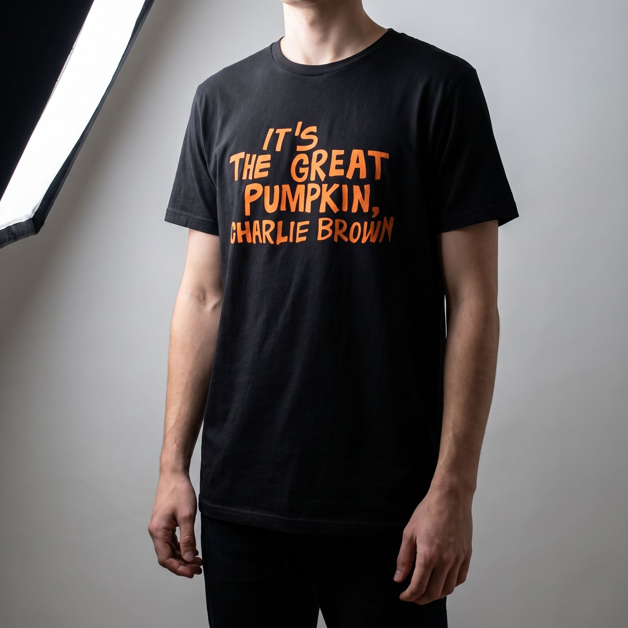 Full-body view of Charlie Brown Great Pumpkin T-Shirt on a model in a minimalist studio, highlighting relaxed fit and print.