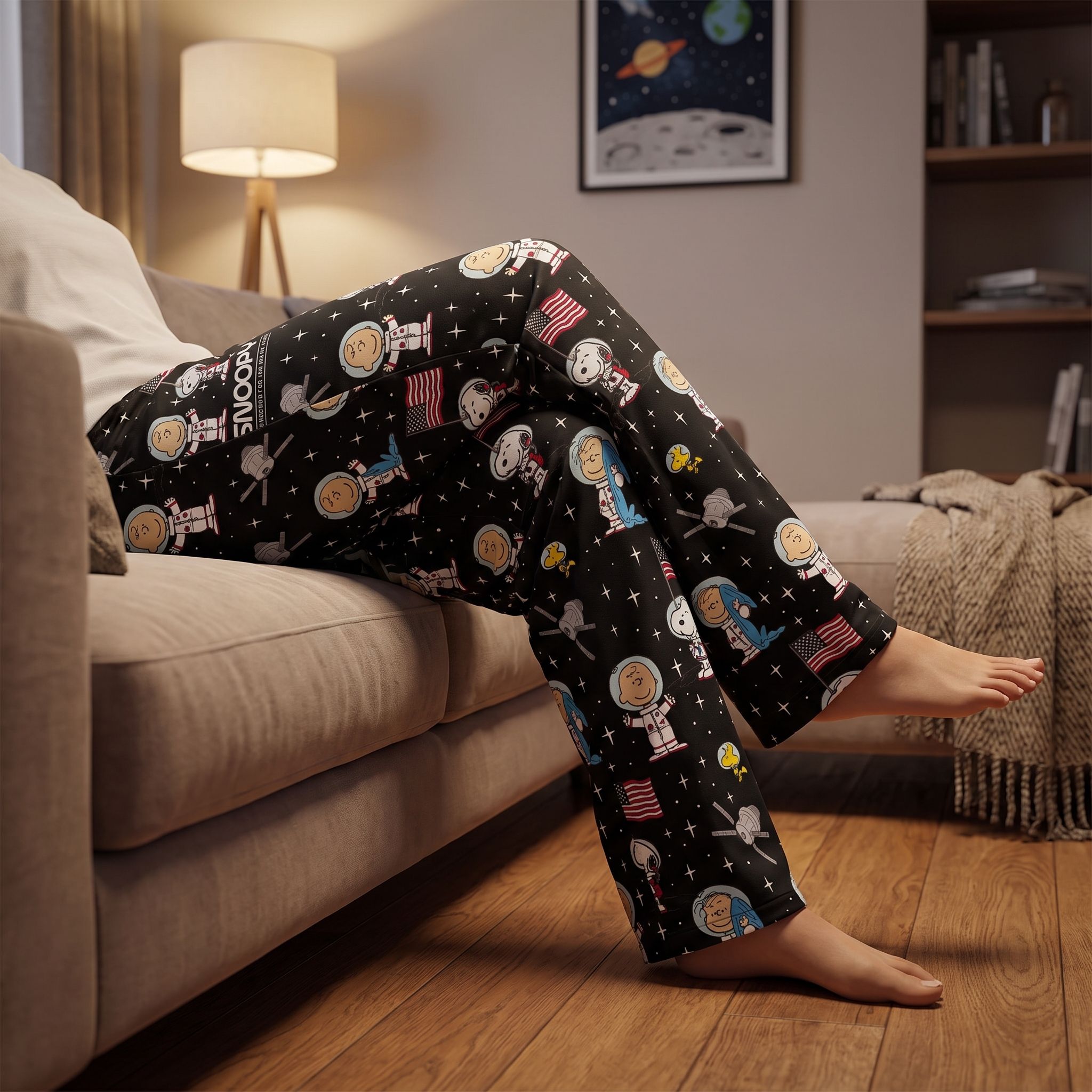Snoopy Space Lounge Pants worn by a relaxed model in a cozy living room with space-themed decor and soft lighting.