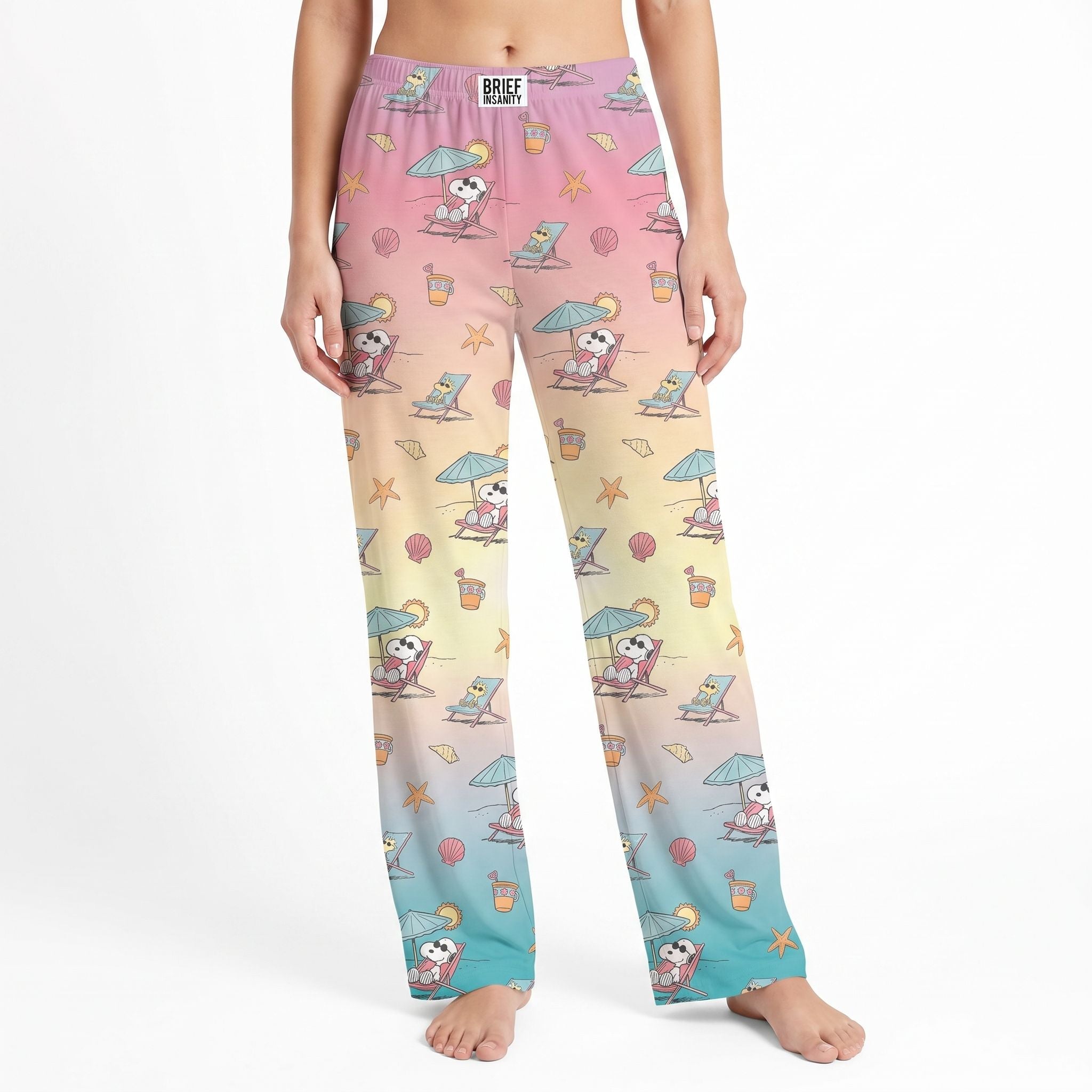 Studio product shot of Snoopy beach lounge pants on a model, centered on white background, showing detailed print and natural fabric drape.