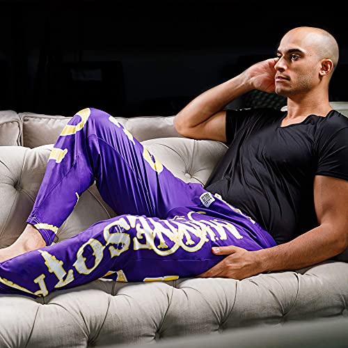 Image of male model sitting on couch wearing SKOL pajama lounge pants (side view)