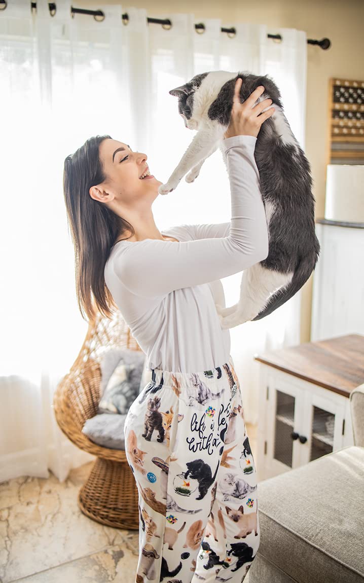 Image of female model holding a cat in the air and wearing Life Is Better With A Cat pajama lounge pants