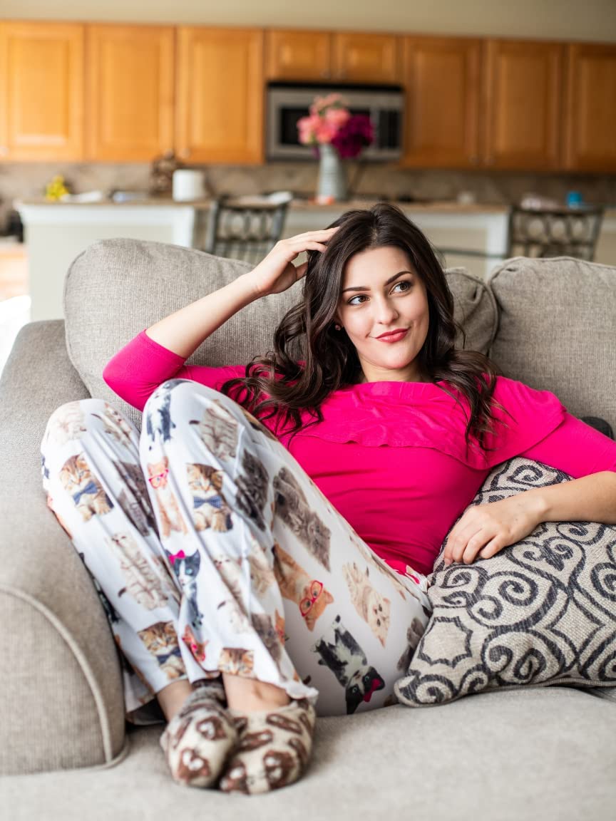 Image of female model sitting on a gray couch wearing Check Meowt pajama lounge pants (front view)