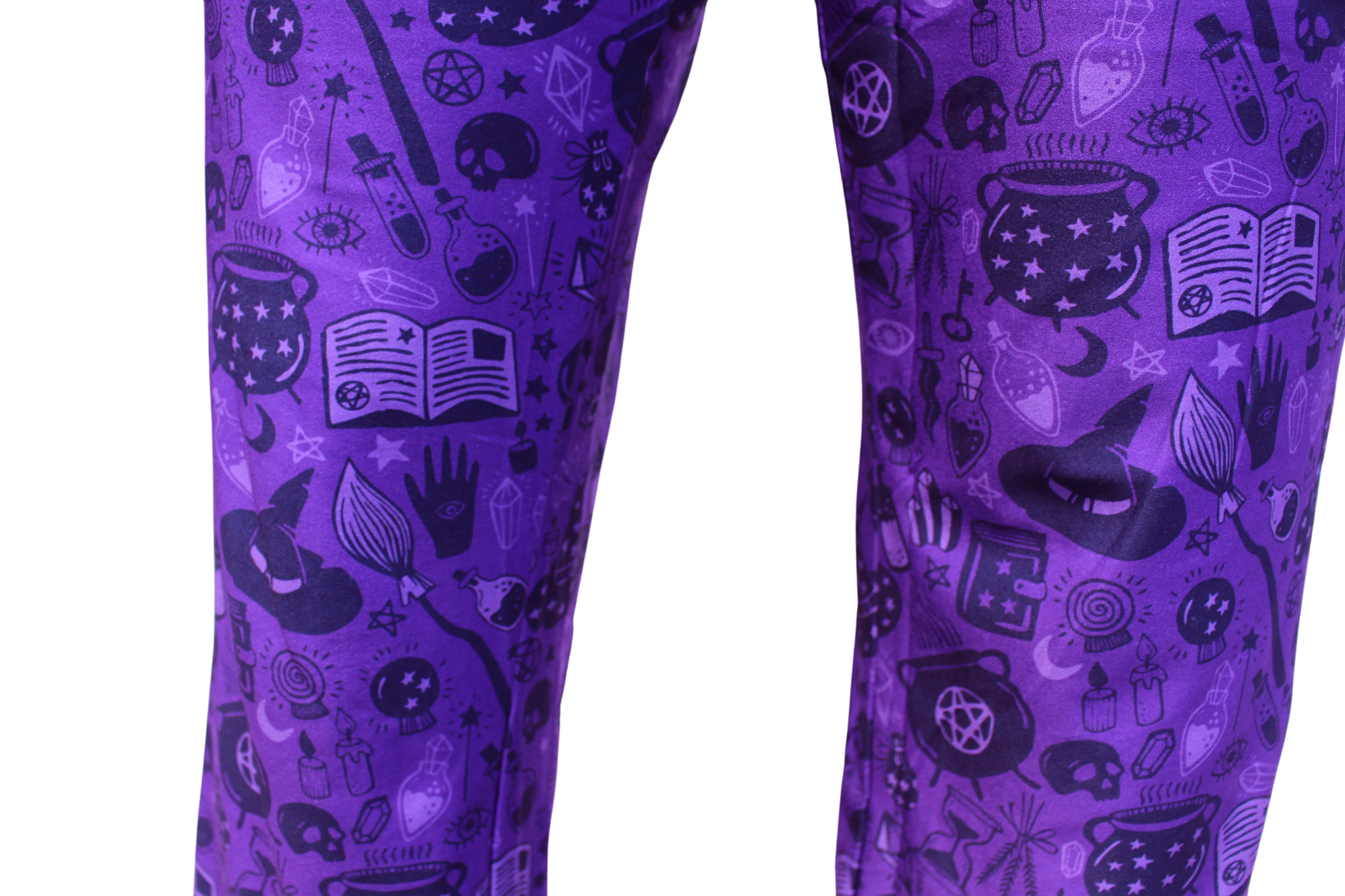 Drink Up Witches Pajama Lounge Pants close up view of pattern on legs (witch hats, brooms, potions, skull heads, stars, candles, diamonds, spell books, eyes)