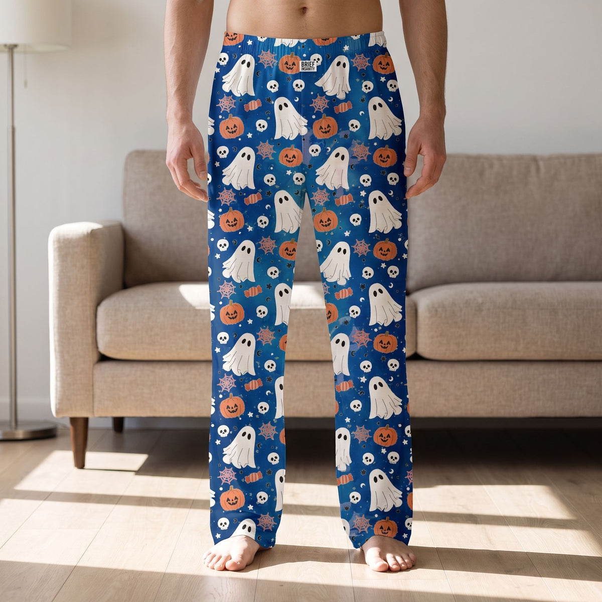 Person wearing blue ghost and halloween candy print lounge pants standing in a contemporary living room.