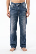 Model wearing blue jeans illusion lounge pants against a white background, showcasing the casual design and fit.