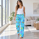 Cancer Warrior Hope blue lounge pants with colorful ribbons and motivational quotes, worn by a model in a minimalist room.