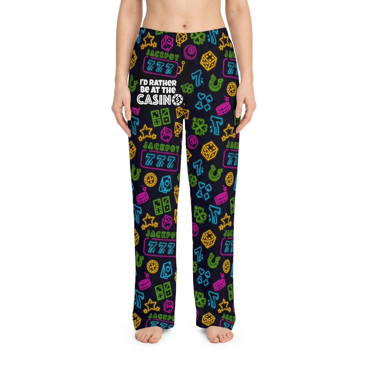 Unisex lounge pants featuring neon casino symbols like dice and lucky 7s on a black background, worn by a model.