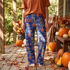 Casual style of Charlie Brown Great Pumpkin Lounge Pants paired with T-shirt, outdoors among fall leaves with dappled sunlight.