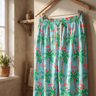 Close-up of Flamingo Christmas Lounge Pants highlighting vibrant flamingo pattern and soft knit texture in cozy indoor setting.