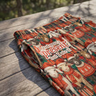 Close-up of Goat You a Present lounge pants showing waistband, pocket, soft fabric, and holiday print outdoors in natural morning light.