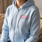 Close-up of Nurse Doodles Zip Up Hoodie highlighting the 'NURSE' graphic on the chest in natural light.
