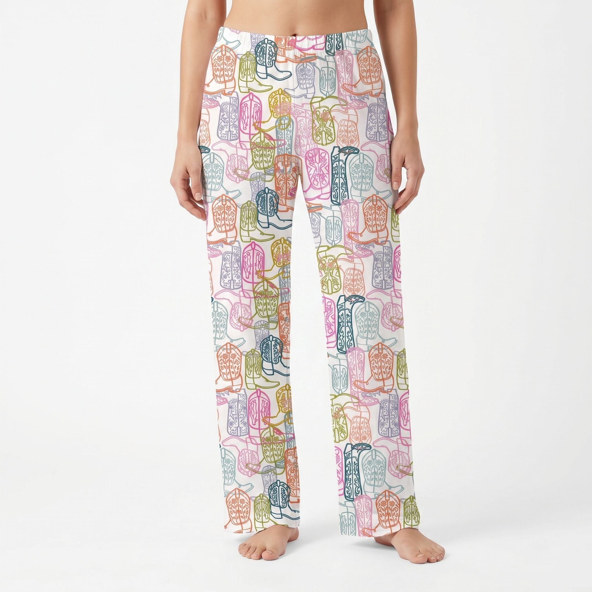Model wearing vibrant cowboy boots lounge pants with playful print, full length, cropped from waist to ankles against white background.