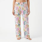 Model wearing vibrant cowboy boots lounge pants with playful print, full length, cropped from waist to ankles against white background.