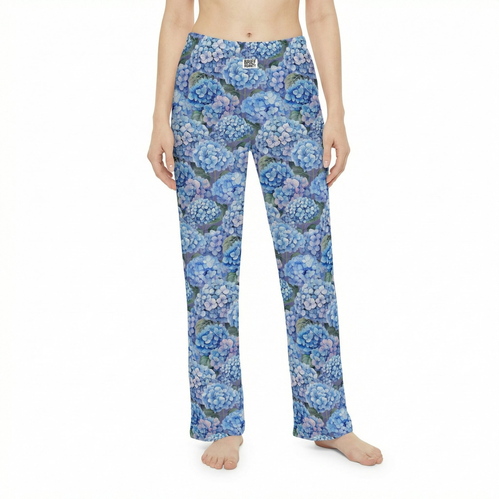 Young woman relaxing on sofa in blue hydrangea lounge pants a cozy living room scene.