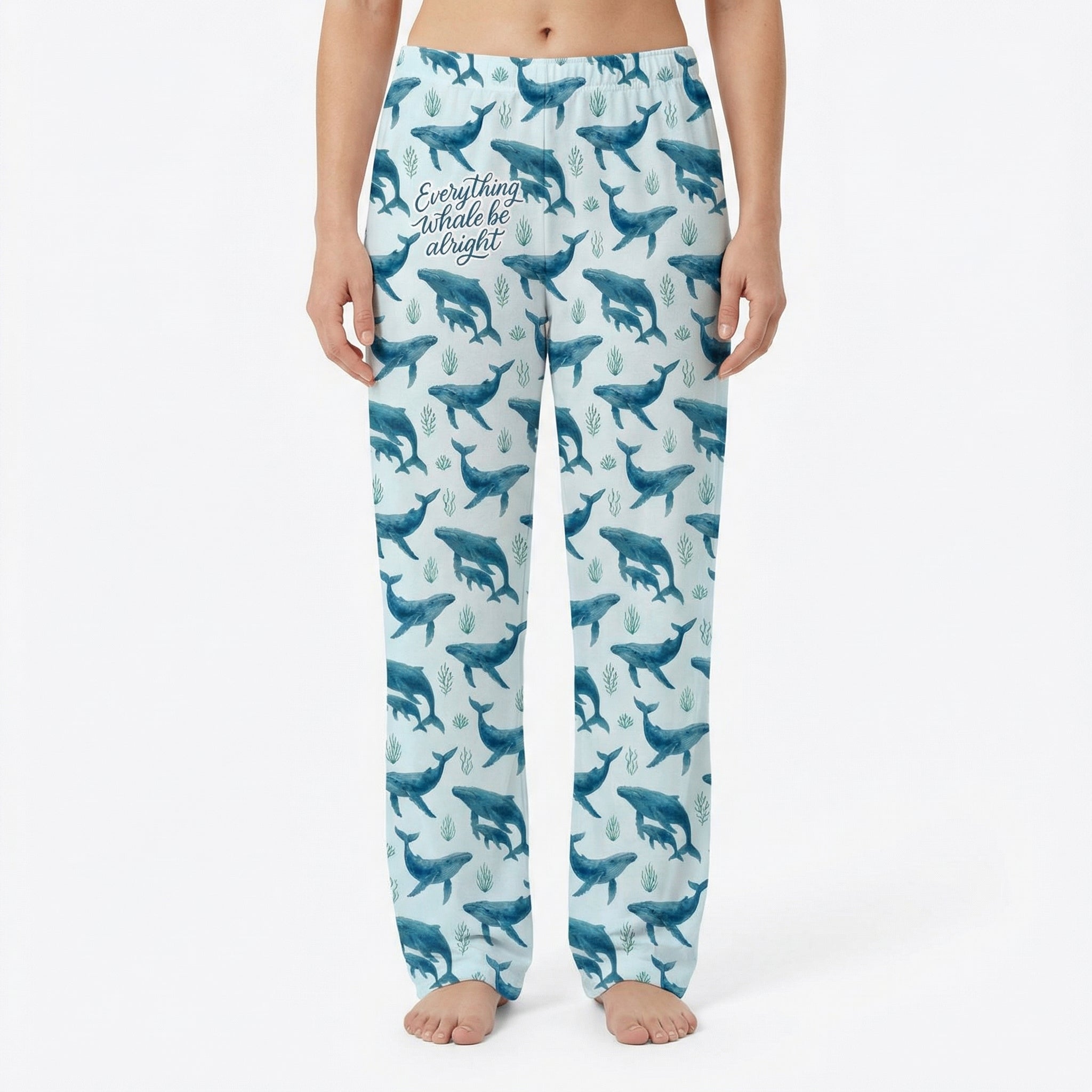 Model wearing Everything Whale Be Alright lounge pants with whale and seaweed print on a white background, centered and fully visible.