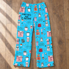 Flat lay view of blue coffee themed lounge pants showing the full pattern of beans and cups on a hardwood floor.