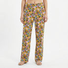 Model wearing floral Tweety lounge pants featuring vibrant garden-inspired print with Tweety accents, set against a white background for product focus.