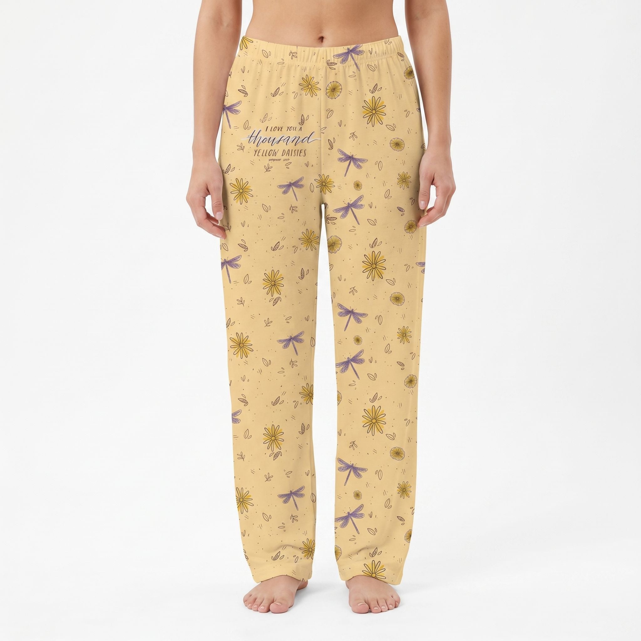 Female model wearing Gilmore Girls yellow daisy lounge pants, cropped from waist to ankles, against a white background.