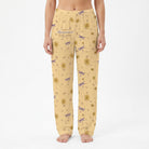 Female model wearing Gilmore Girls yellow daisy lounge pants, cropped from waist to ankles, against a white background.