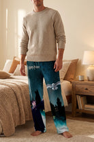 Male model wearing Harry Potter Hedwig's Flight pajama pants in a cozy bedroom setting with warm tones and minimal decor, emphasizing comfort and the detailed print.