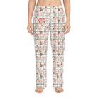 Model wearing I Goat You Babe Lounge Pants with all-over goat print on plaid background, cropped from waist to ankles against a white background.