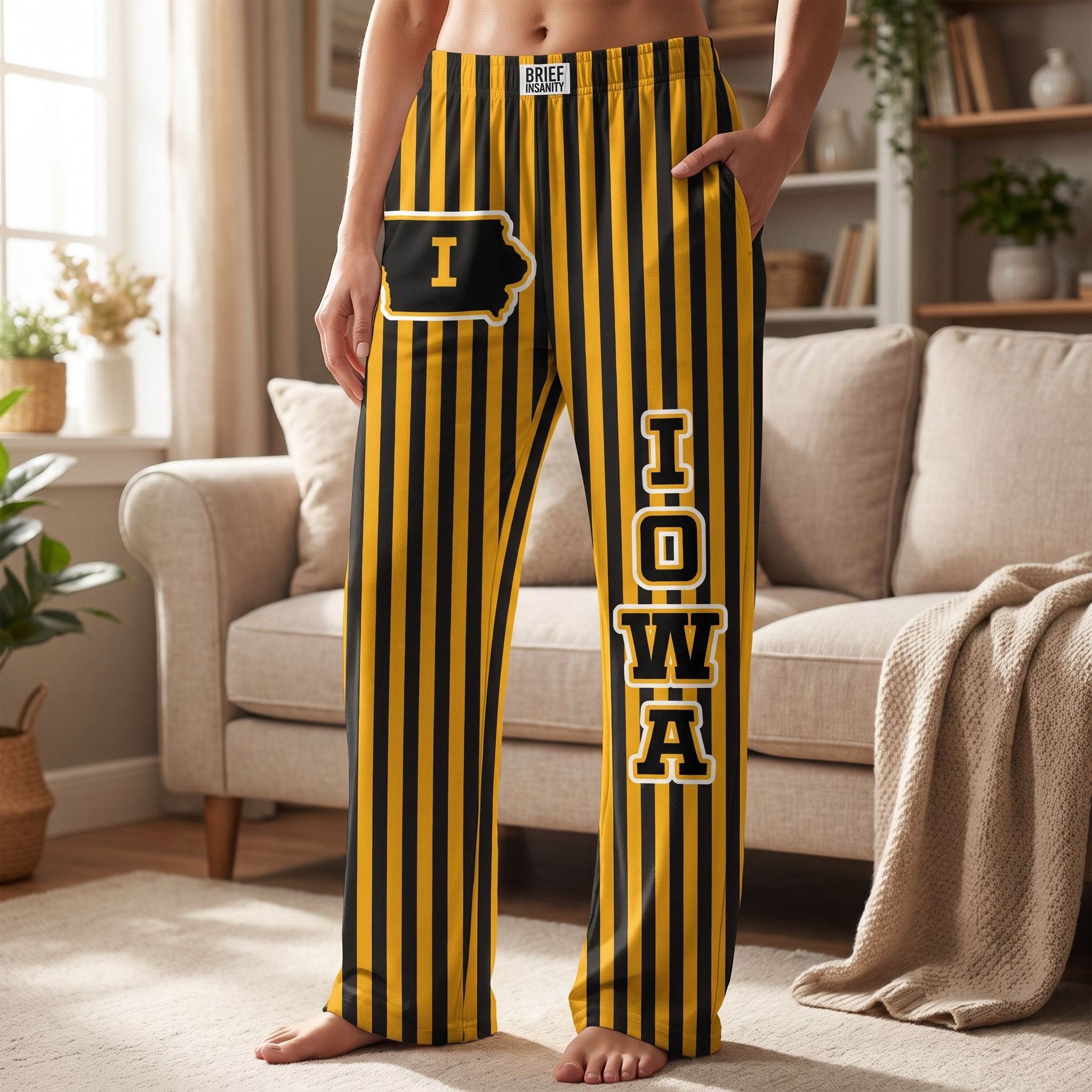 Full-body view of person wearing Iowa striped pajama pants in cozy living room setting, highlighting relaxed fit and design.
