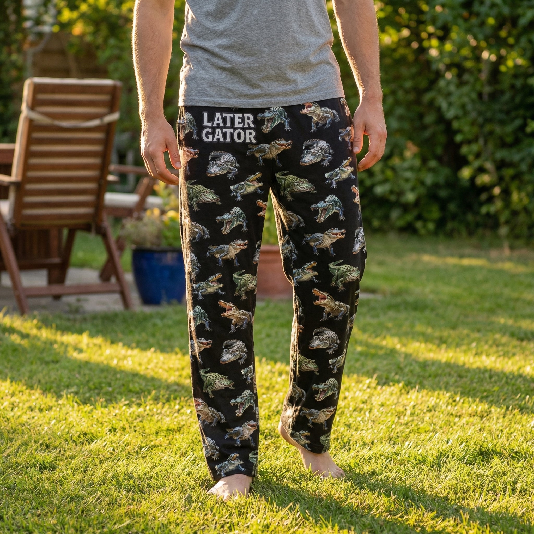 Male model wearing alligator print lounge pants outdoors in sunny backyard, relaxed and natural pose, pants in focus.