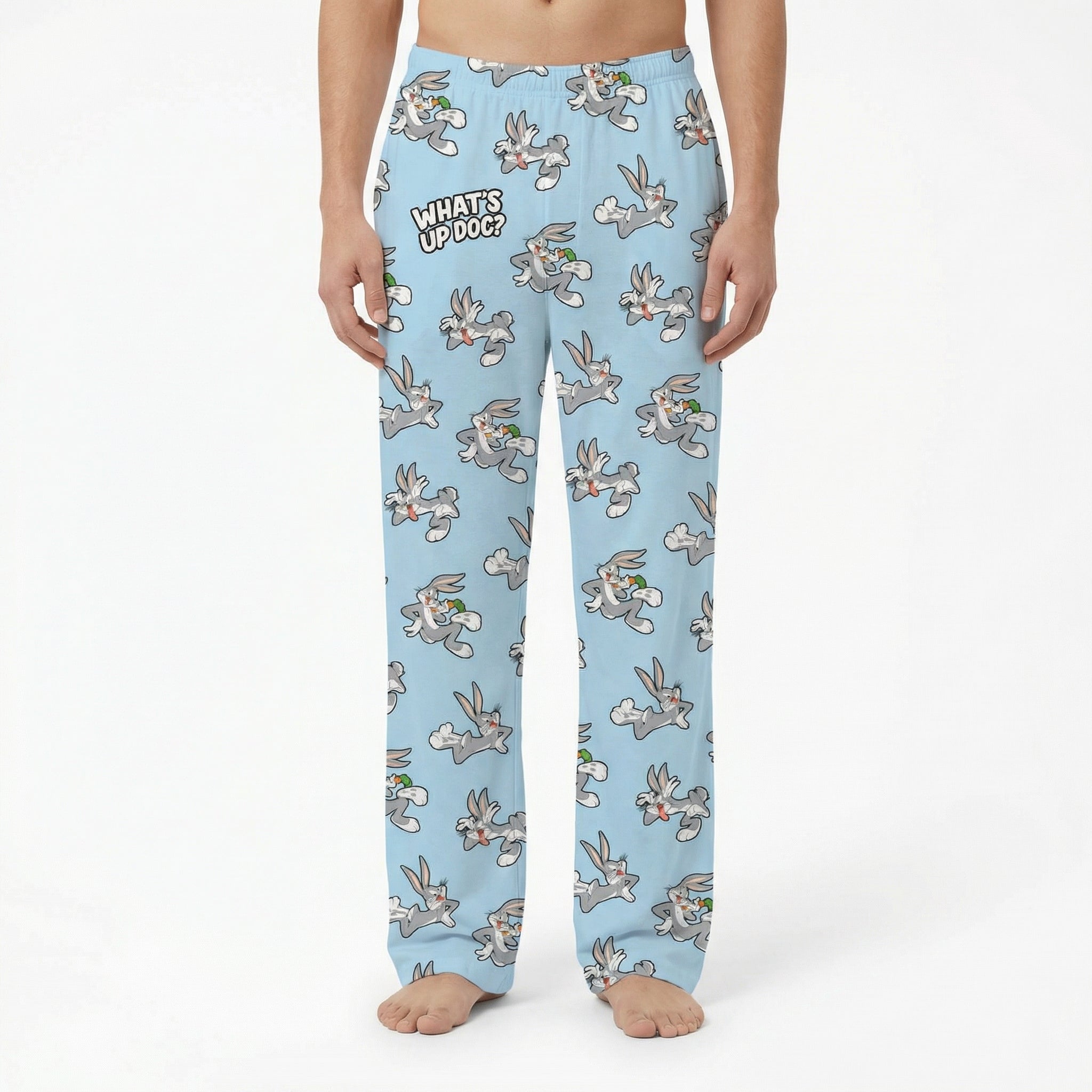 Model wearing Bugs Bunny lounge pants with Looney Tunes print on white background, cropped from waist to ankles.
