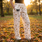 Model wearing Brewin' Trouble & Gooses lounge pants outdoors during golden hour, showcasing relaxed fit, whimsical Halloween print, and cozy style.