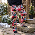 Model standing on outdoor patio in Ralphie Fudge lounge pants with greenery and holiday lights, showcasing relaxed fit and cozy fabric texture.