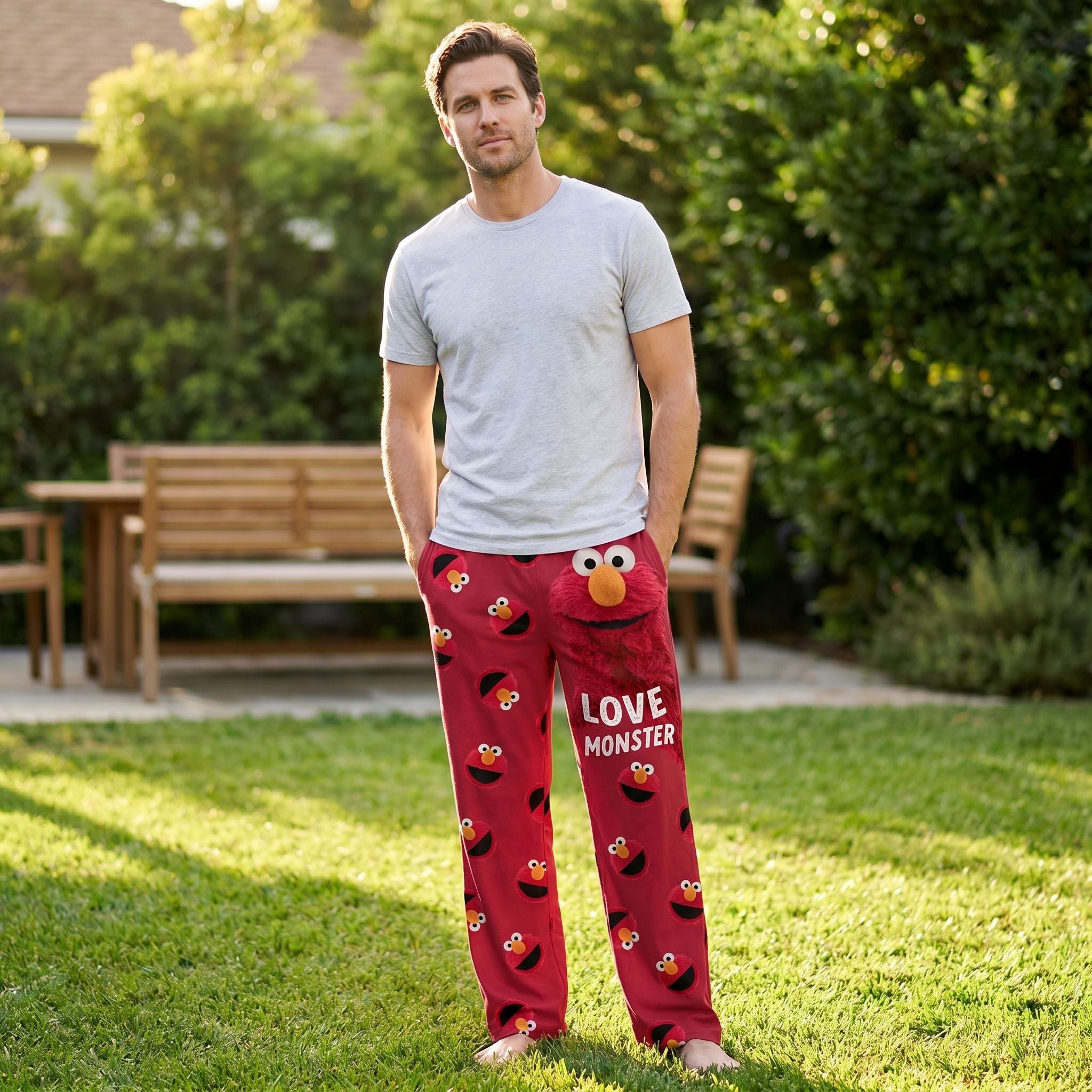 Male model wearing Sesame Street Elmo Love Monster lounge pants outdoors with relaxed pose and natural background.
