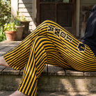 Person sitting outdoors on porch wearing Iowa striped pajama pants, showcasing casual style and comfortable fabric.