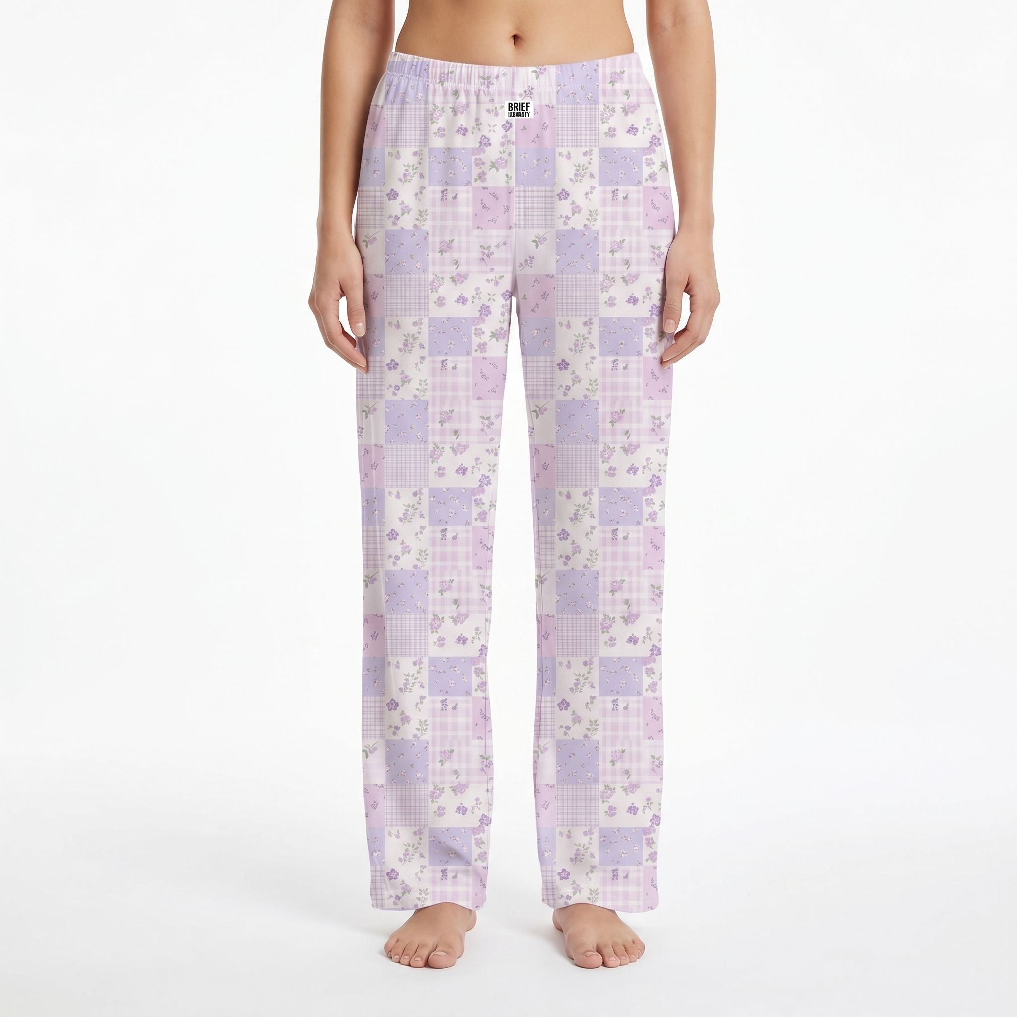 Model wearing purple floral lounge pants with plaid accents, showing vibrant colors and fabric details against a white background.