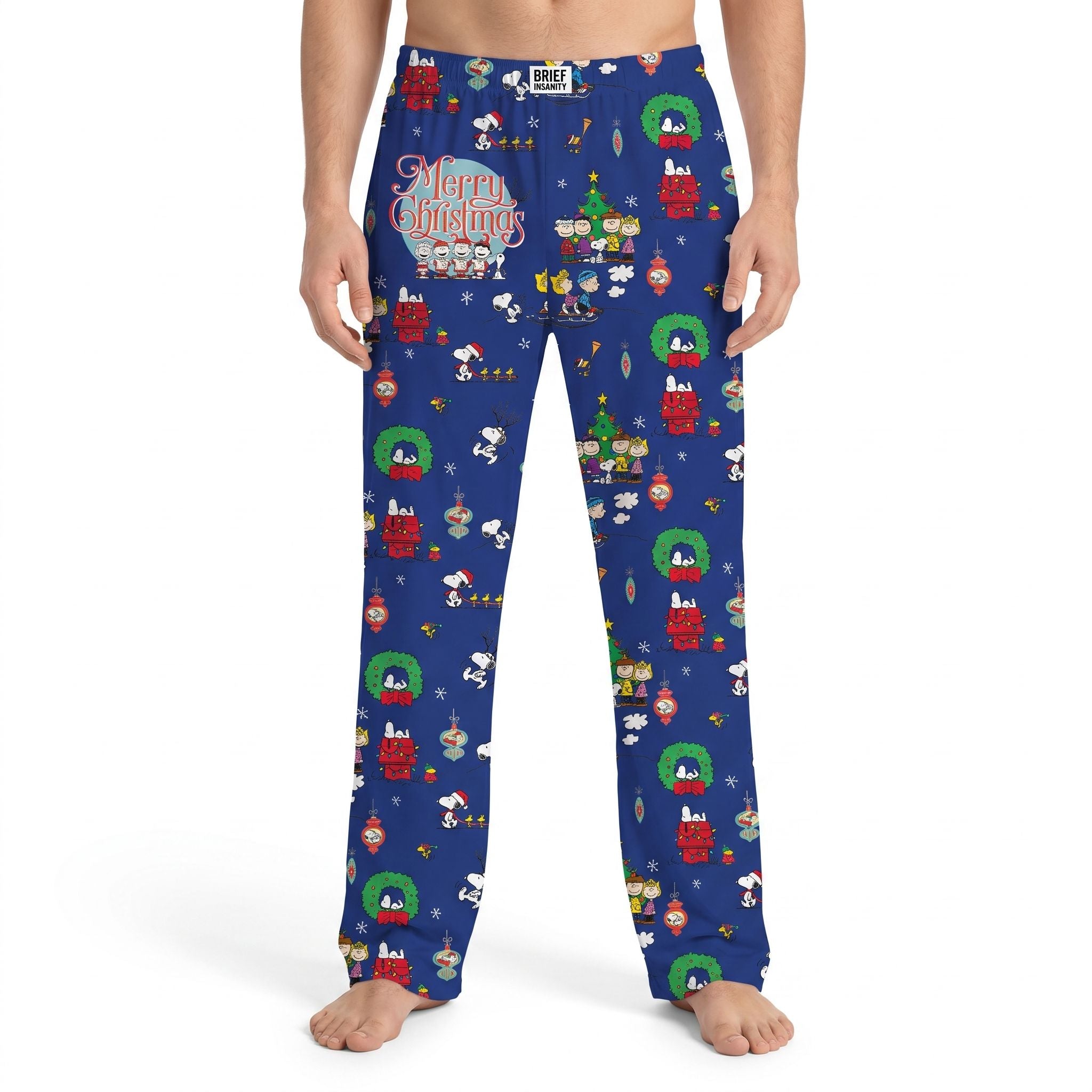 Close-up of Snoopy & Friends Xmas lounge pants showing soft knit fabric, vibrant Peanuts print, and 'Merry Christmas' text on a relaxed model.