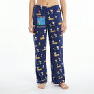 Young female model wearing Snoopy fishing lounge pants with vivid print on white background.