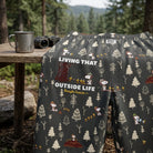 Close-up of Snoopy Outside Life lounge pants showing detailed woodland print and fabric texture under natural light.