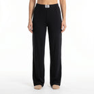 Model wearing solid black lounge pants cropped from waist to ankles against a white background, showcasing the relaxed fit and fabric texture.