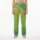 Young female model wearing soccer lounge pants with soccer ball print on white background.