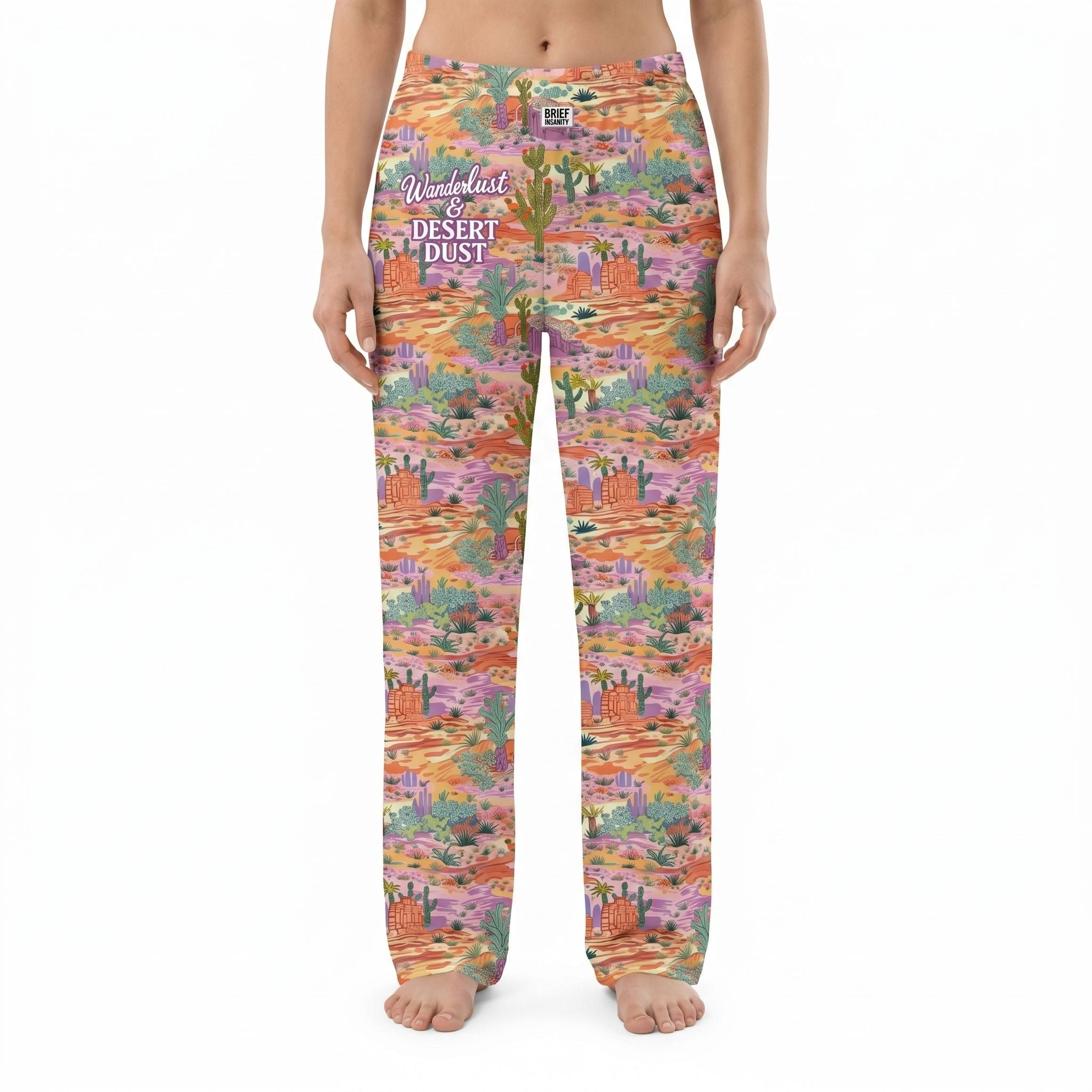 Model wearing vibrant desert landscape lounge pants against white background, fully visible, cropped from waist to ankles, showcasing print details.