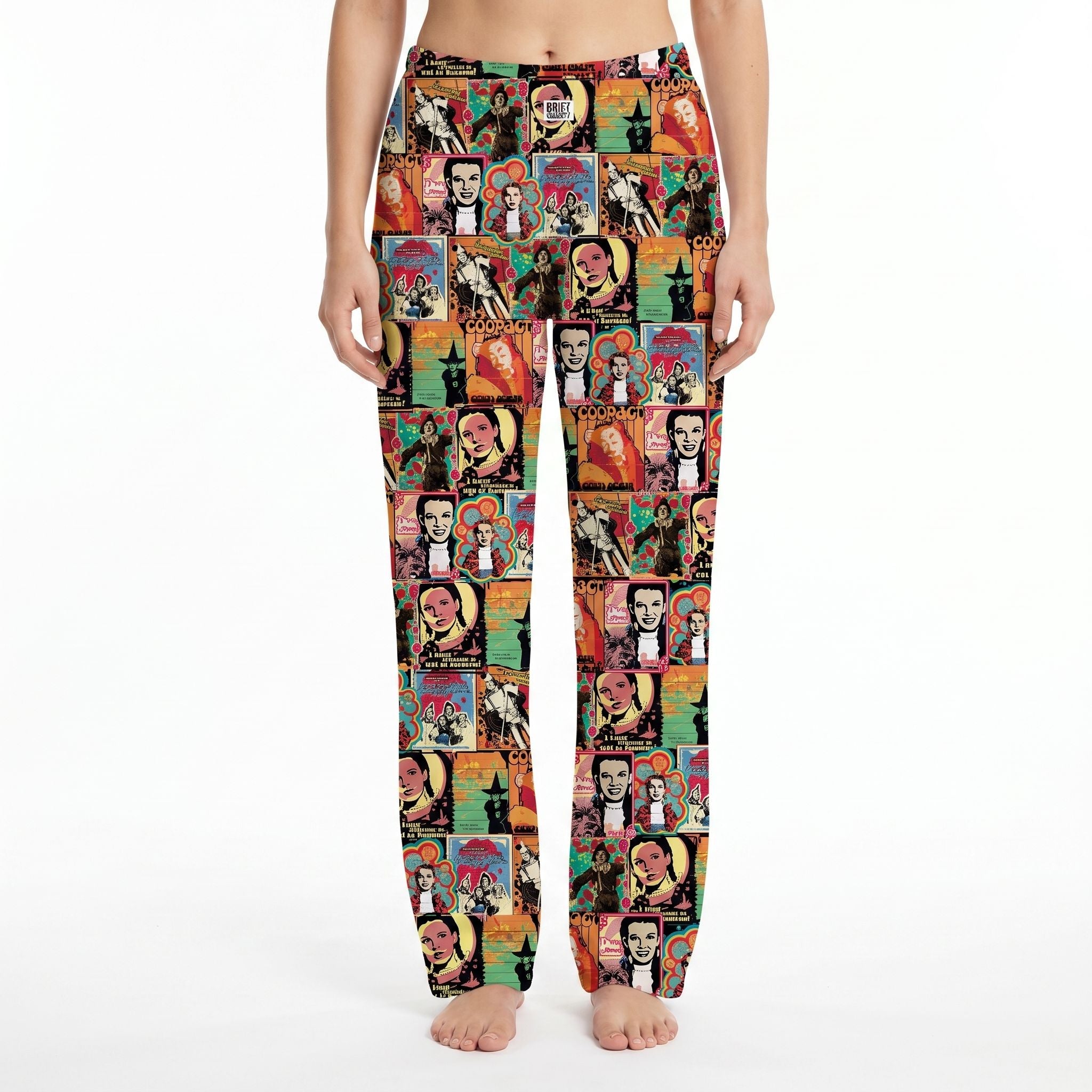 Female model wearing vibrant Wizard of Oz pop art poster lounge pants on white background, fully visible and centered.