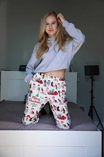 Image of female model kneeling on bed posing wearing Meowy Christmas pajama lounge pants (front view)