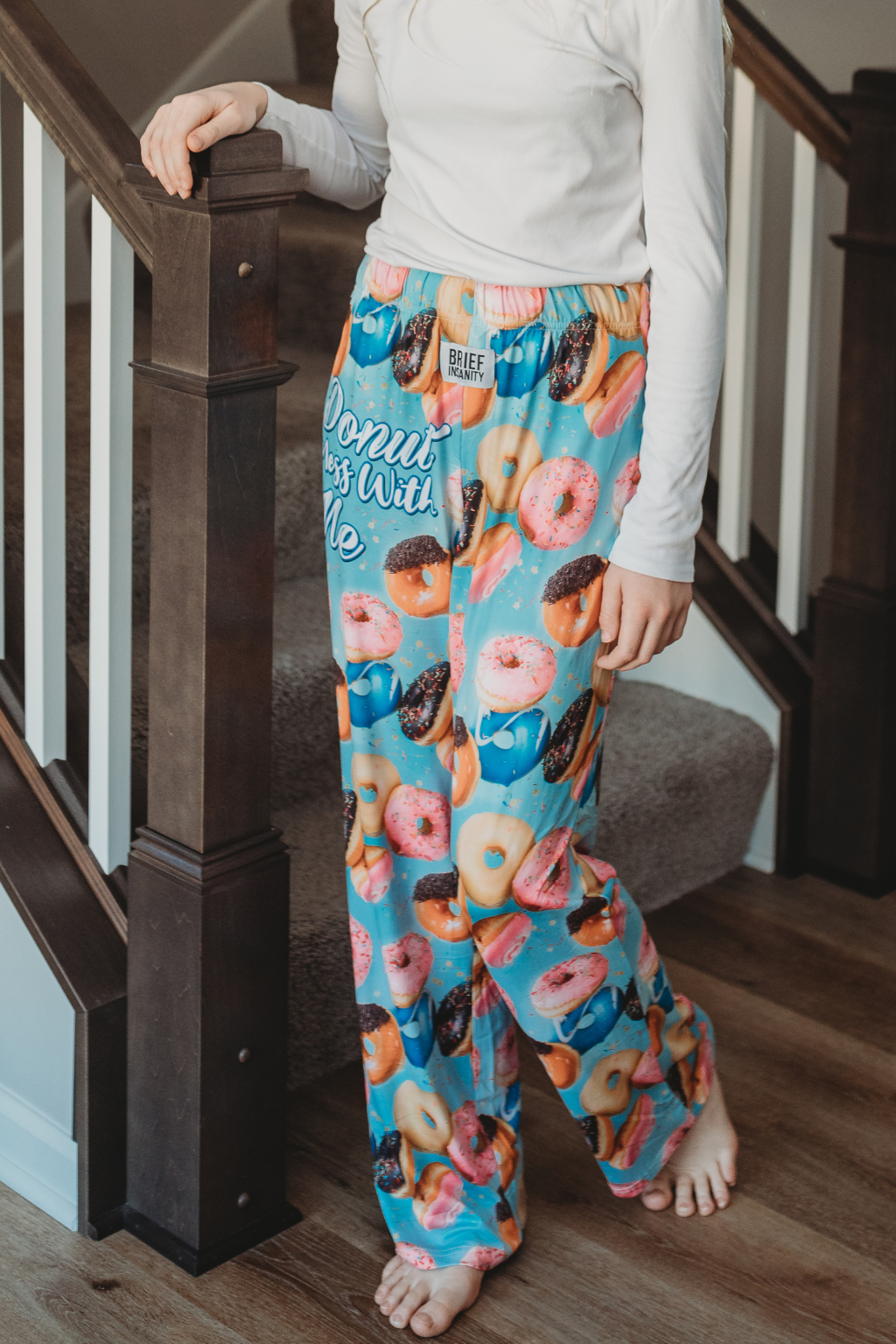 Image of model walking down the end of stairs posing wearing Donut Mess With Me pajama lounge pants (front view)