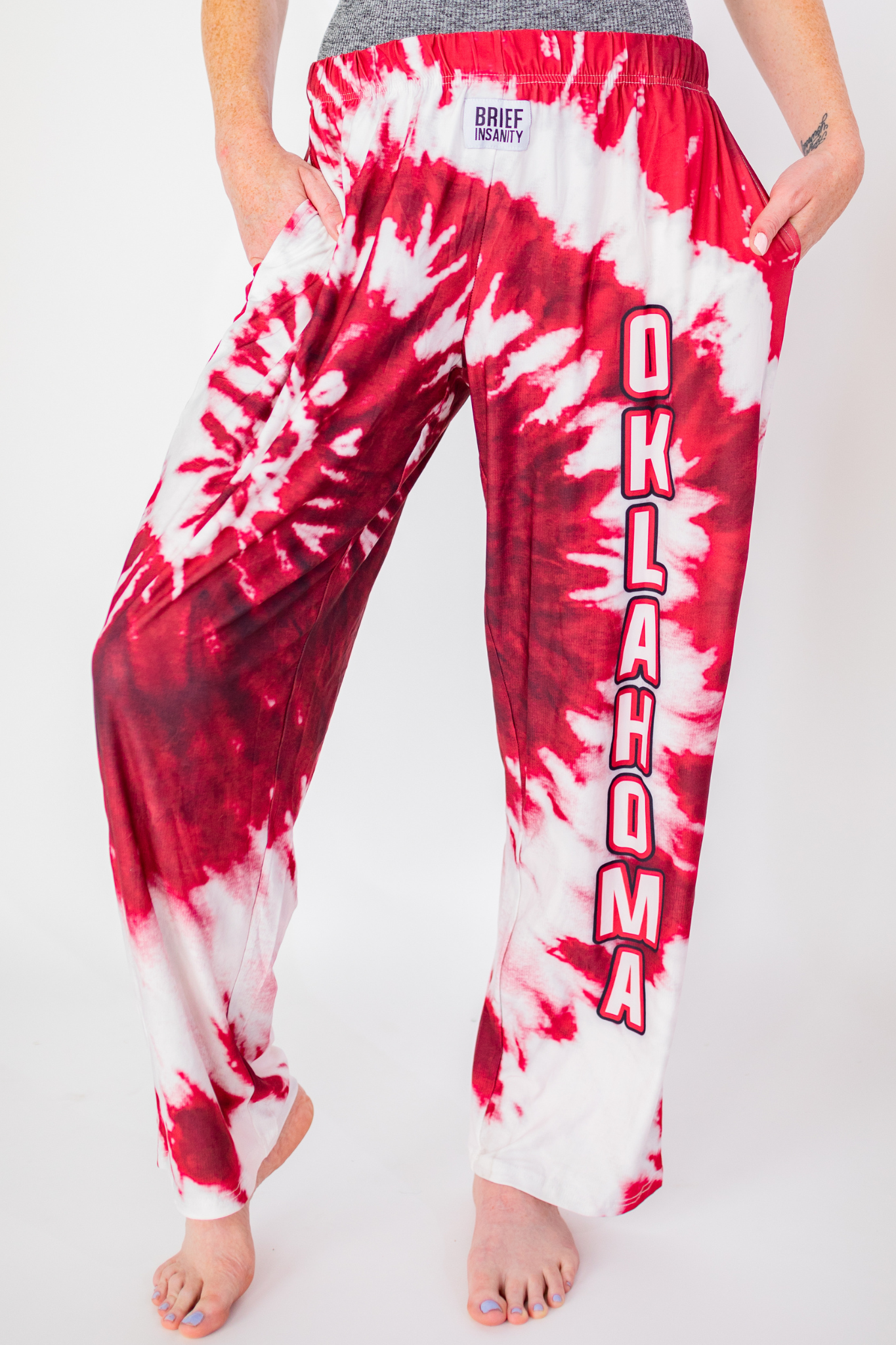 Waist down photo of model wearing Oklahoma Red Tie-Dye pajama lounge pants front view (white background)
