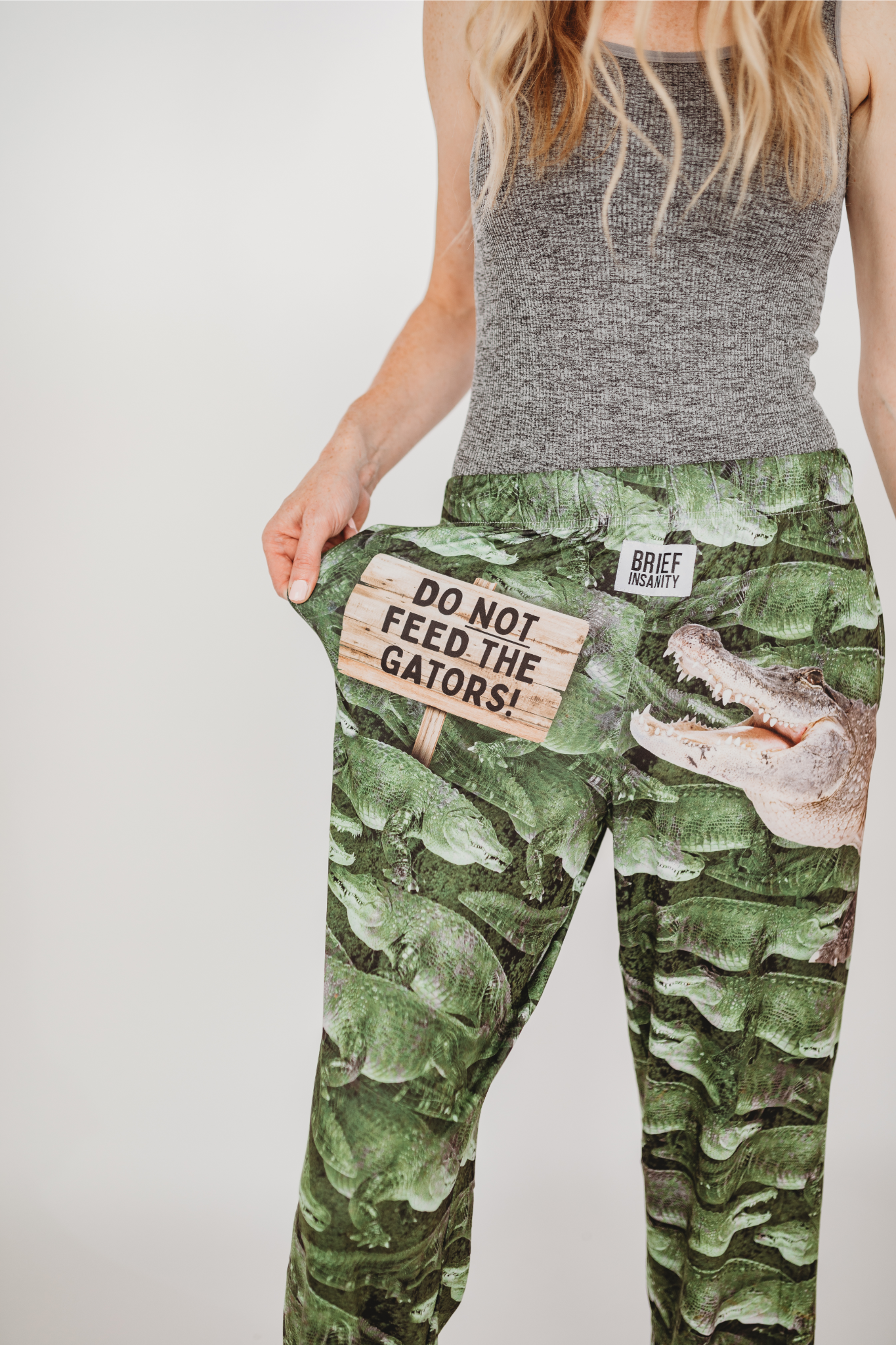 Image of model wearing Do Not Feed The Gators pajama lounge pants front view showing off text (white background)