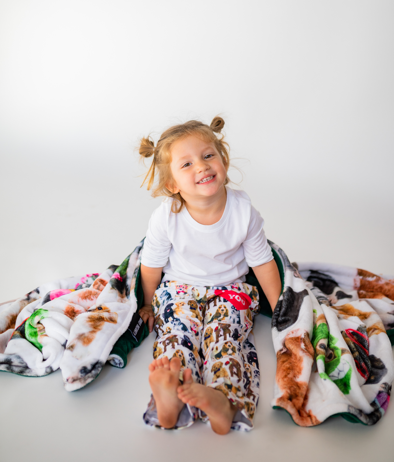 Toddler wearing Briefly Kids I Ruff You Pajama Lounge Pants wrapped in a cozy Life is Better with a Dog Throw Blanket