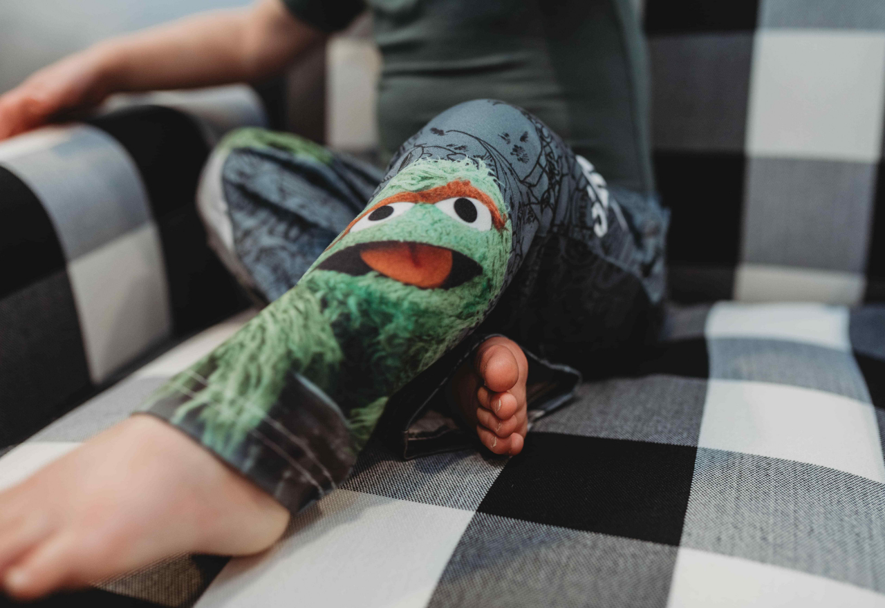 Close up image of the legs of little girl model wearing Sesame Street Oscar The Grouch pajama lounge pants